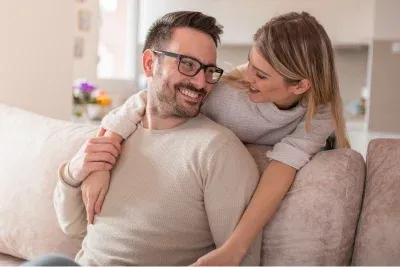 Couple who met through a matchmaker in Indianapolis hugging on their couch