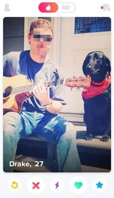 Man playing guitar on his porch with his dog next to him