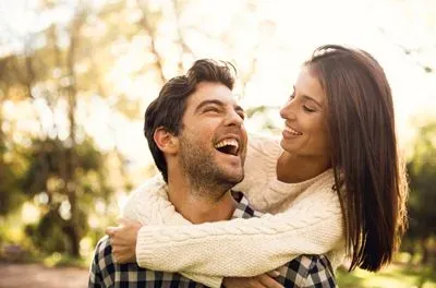 Happy couple hugging outside in a park