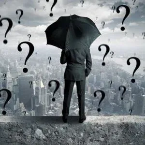Illustration of man with umbrella standing on wall overlooking city surrounded by question marks