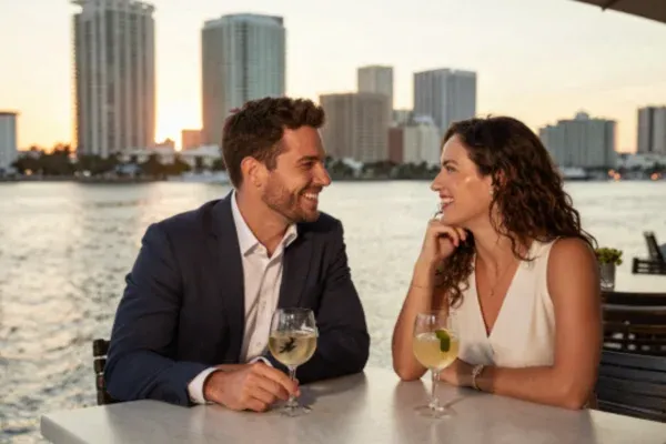 Attractive man and woman on a date enjoying a glass of wine sitting by the ocean in Tampa Bay