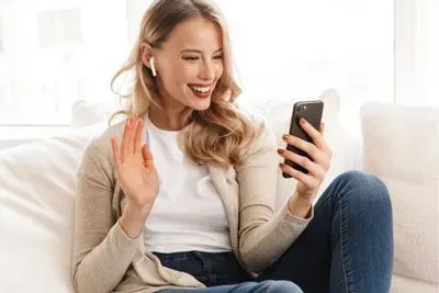Woman waving to a match on a video date